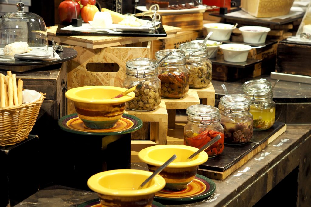 Buffet table with bowls of spices and pickled vegetables 