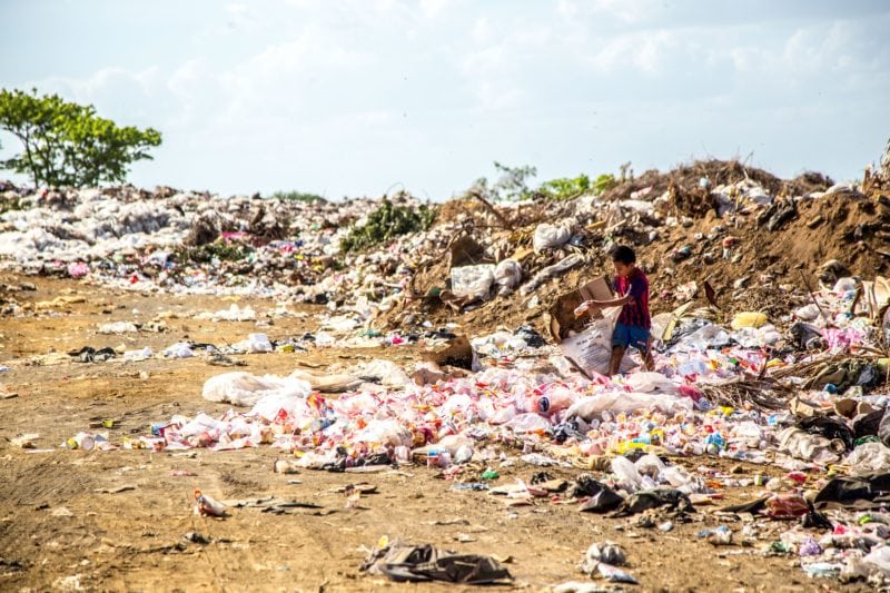boy picking plastic in landfill