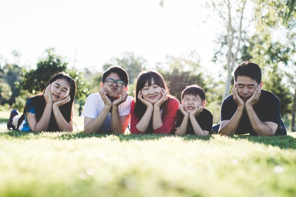 family of 5 on lawn with faces in their hands