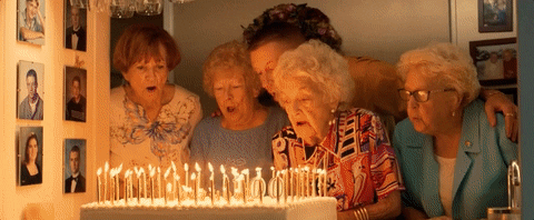 old lady blowing candles