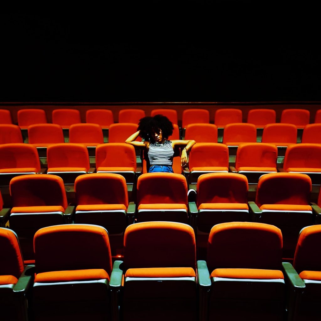 cinema hall with one viewer on red seats