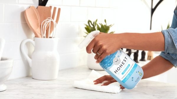 Disinfectant spray held in hand and applied on counter top