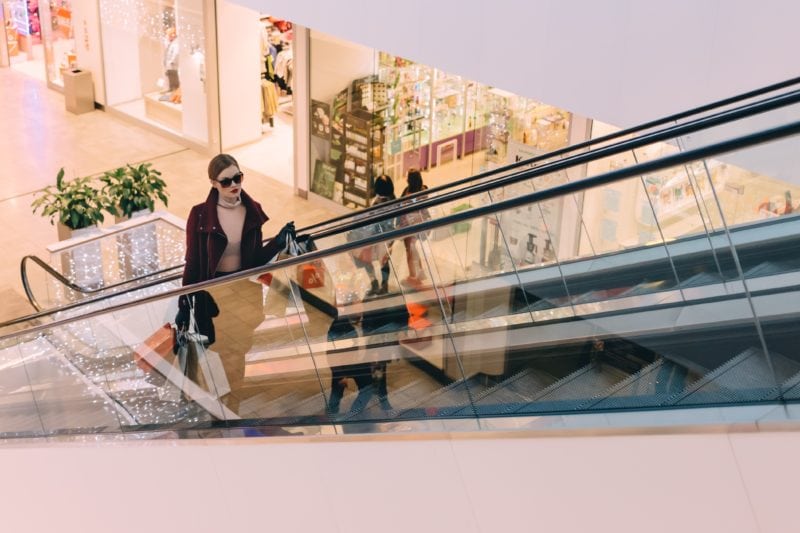 Shopper on escalator in mall