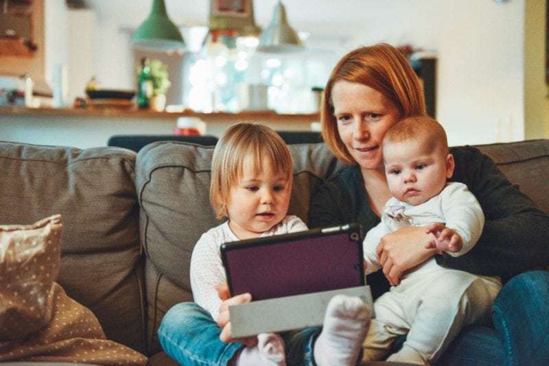 Mother showing a tablet with learning apps to her kids