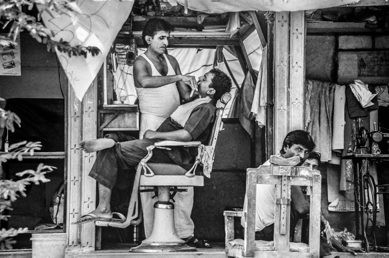 Black and white image of Indian barber on the streets