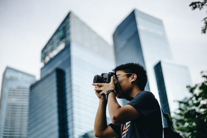 Asian guy photographing like a professional in the city