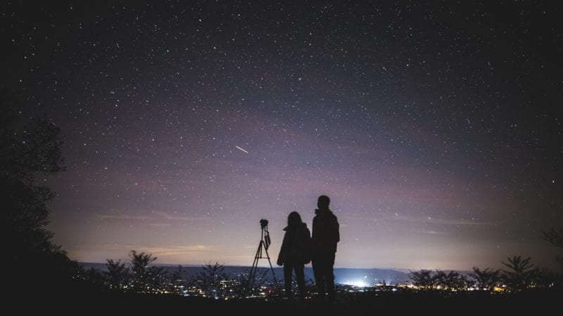 couple stargazing with telescope