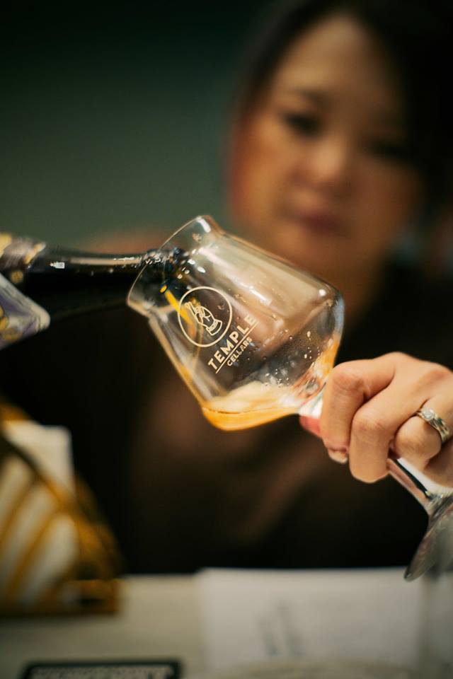 female server pouring beer into glass