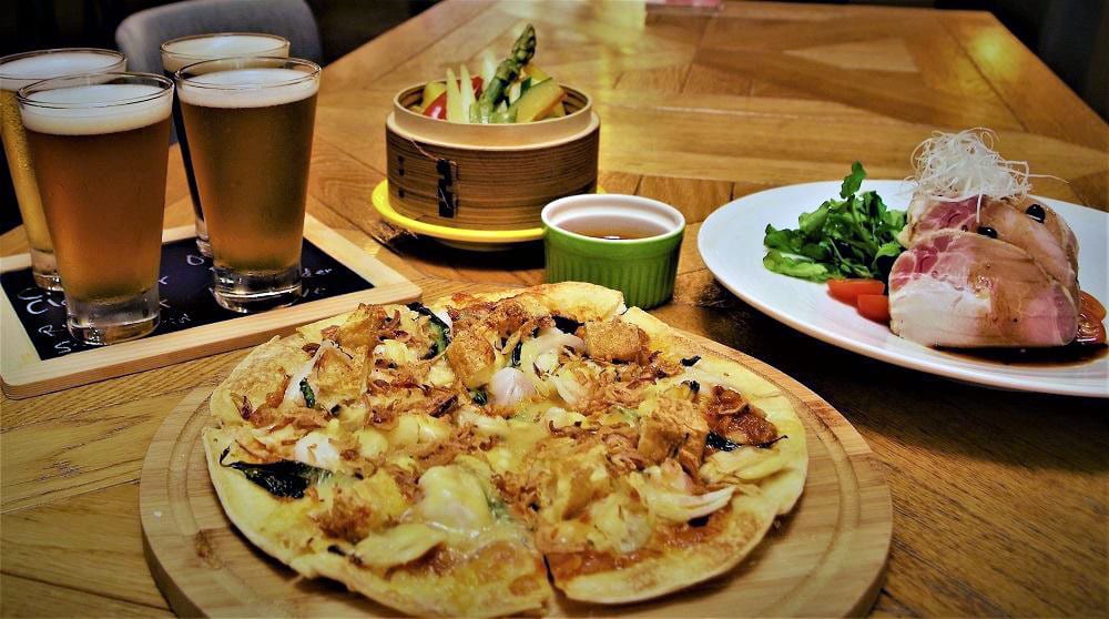 pizza and sides with four cups of beer
