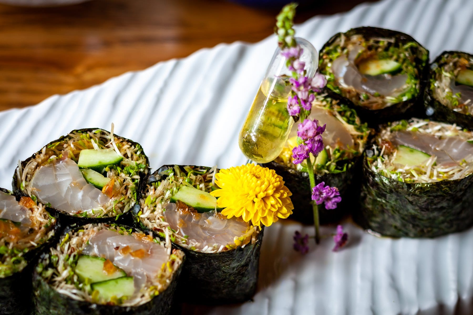 fresh sashimi sushi with seaweed and edible flowers