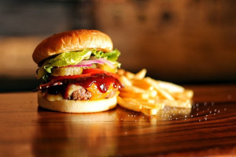 cheeseburger with fries on a wooden table top