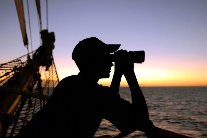 shadow of a photographer out at sea during sunset