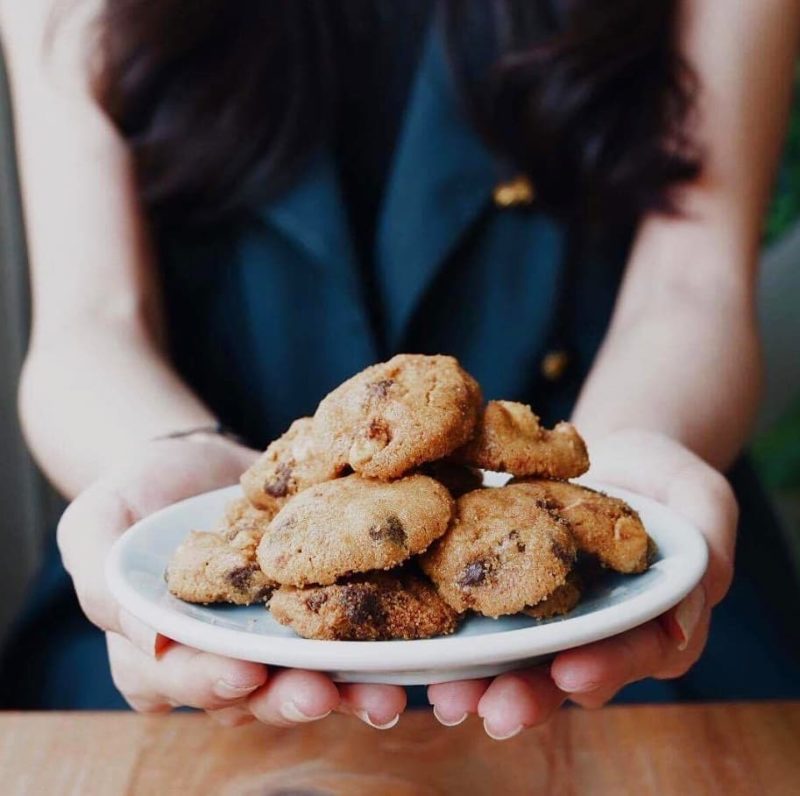 woman holding a plate of famous amos no nut chocolate chip cookies